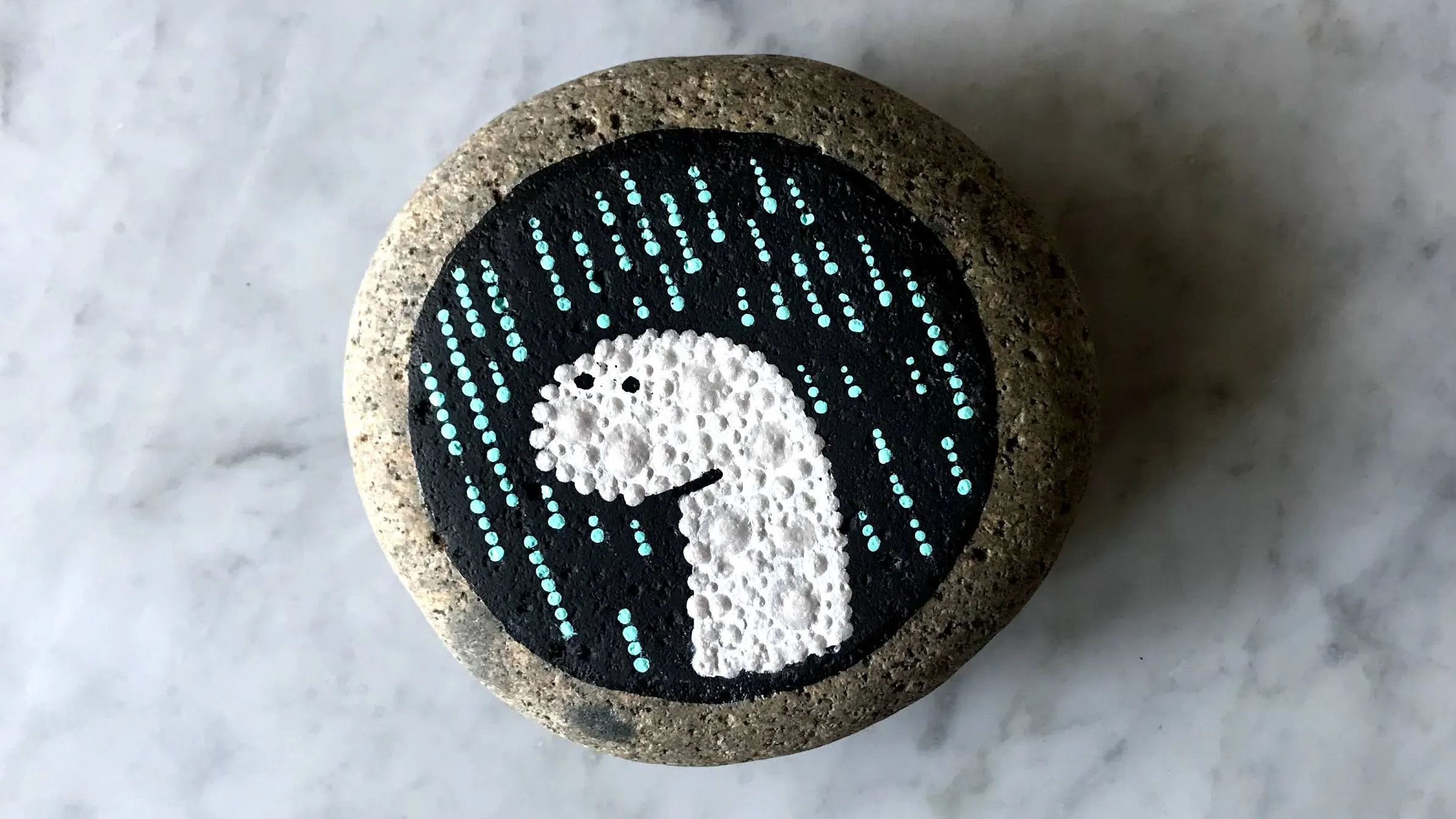 A stone hand-painted as Deno's dinosaur mascot
